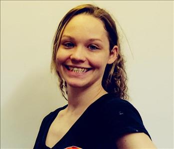 smiling young woman wearing a black shirt against a white background